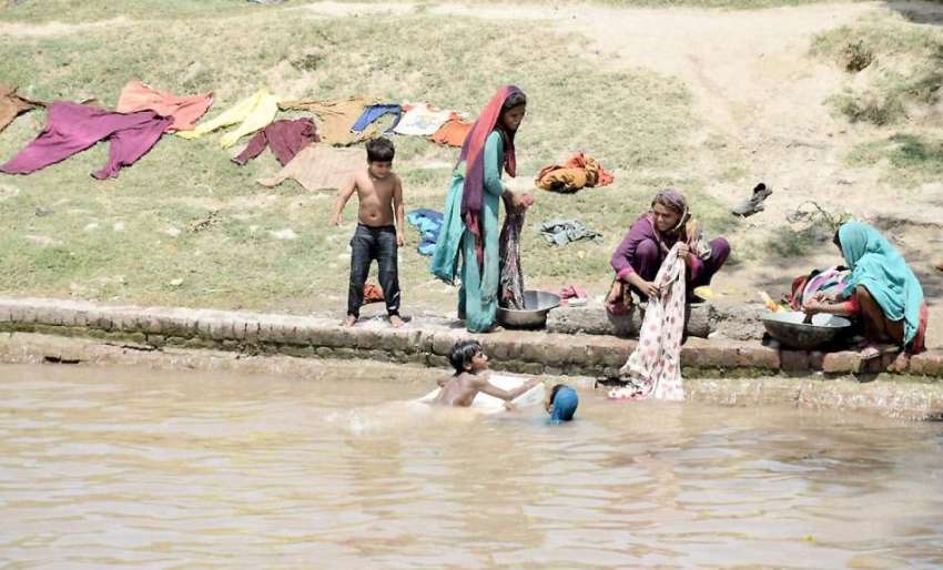 لاہور: خانہ بدوش خواتین نہر کنارے کپڑے دھو رہی ہیں جبکہ بچے ..