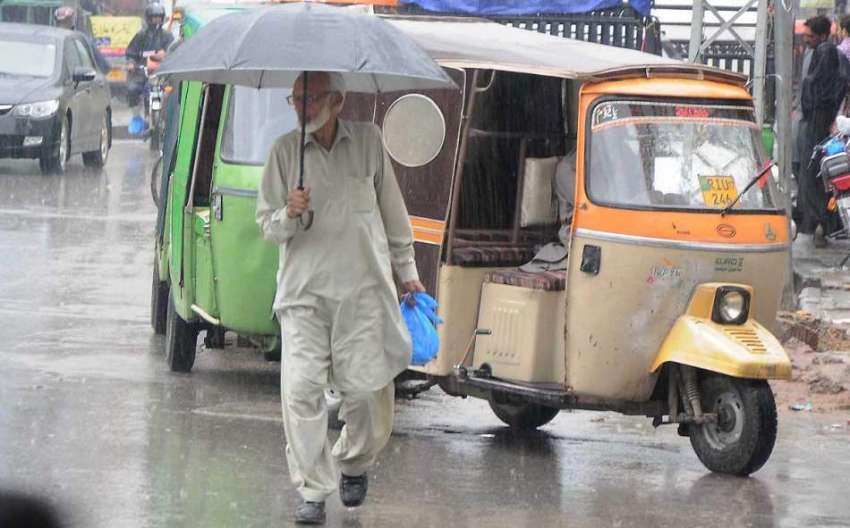 راولپنڈی: بارش سے بچنے کے لیے معمر شخص چھتری تھامے کمیٹی ..