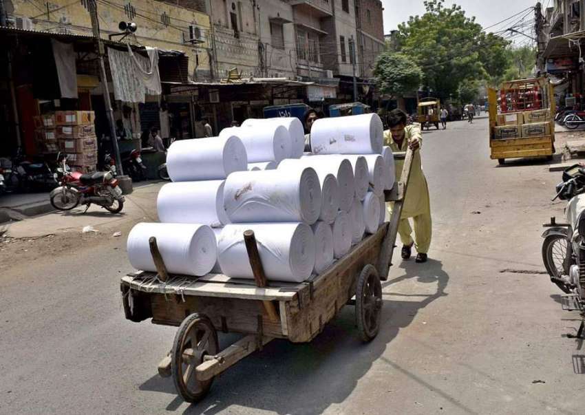 فیصل آباد: مزدور ہتھ ریڑھی پر کپڑا لوڈ کیے مارکیٹ سپلائی ..