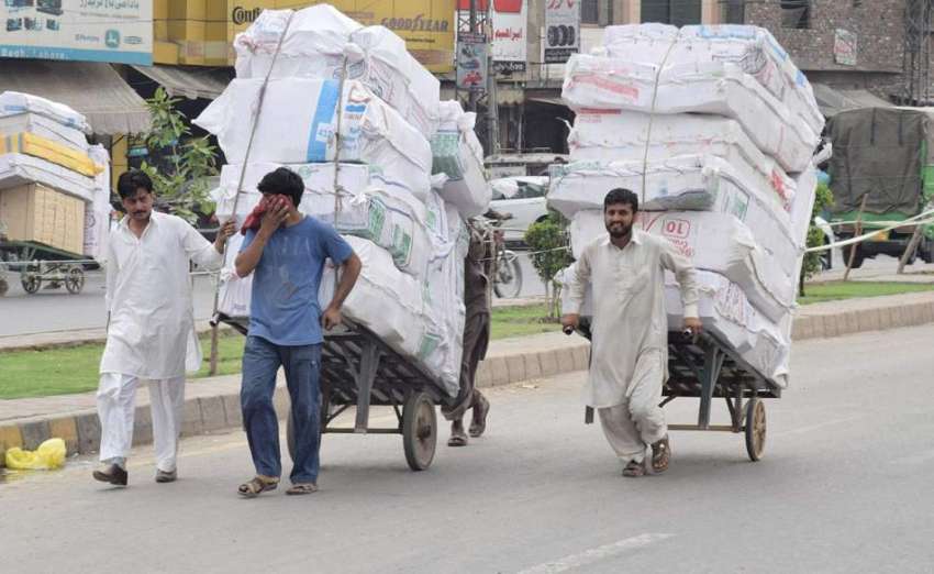 لاہور: محنت کش ہتھ ریڑھیوں پر بھاری سامان رکھے جا رہے ہیں۔