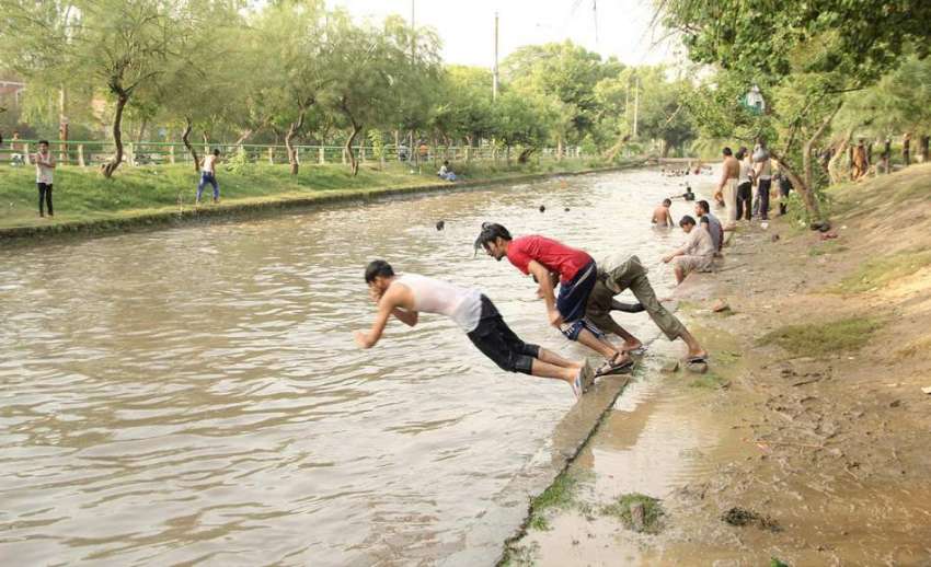 لاہور: نوجوان گرمی کی شدت کم کرنے کے لیے نہر میں نہارہے ہیں۔