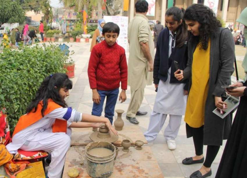 لاہور: چلڈرن کمپلیکس میں جاری فیسٹیول میں ایک بچی مٹی کے ..