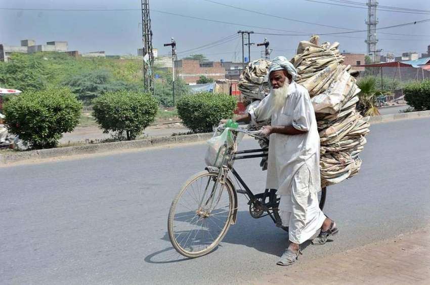 فیصل آباد: ایک معمر محنت کش سائیکل پر سیمنٹ کے خالی تھیلے ..