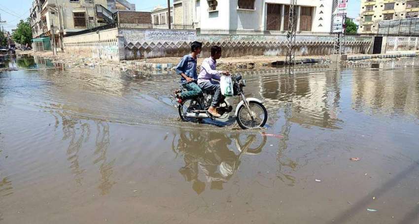 حیدر آباد: موٹر سائیکل سوار بارش کے جمع شدہ پانی سے گزر رہے ..