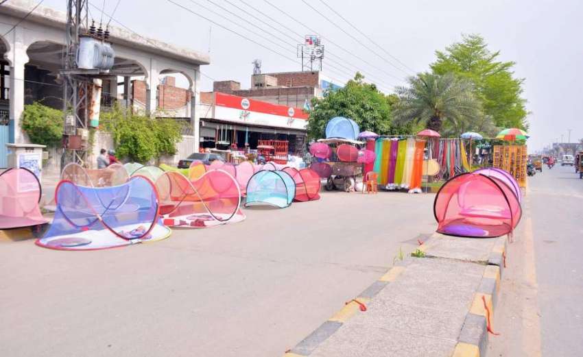 فیصل آباد: محنت کش نے سڑک کنارے فروخت کے لیے مچھردانیاں سجا ..