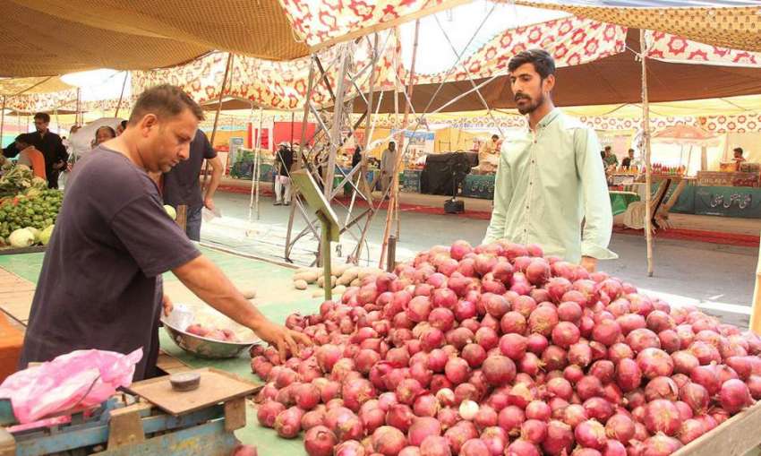لاہور:ایک شہری شادمان سستے رمضان بازارمیں سٹال سے پیاز خرید ..