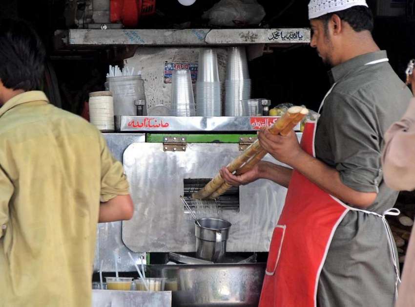 راولپنڈی: دکاندار مشین سے گنے کا رس نکالنے میں مصروف ہے۔