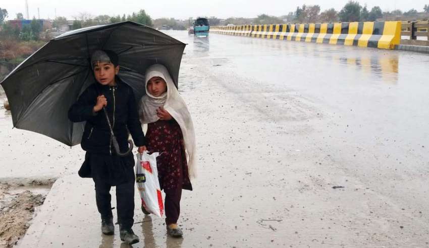 کوہاٹ: کمسن بچے بارش سے بچنے کے لیے چھتری تانے جا رہے ہیں۔