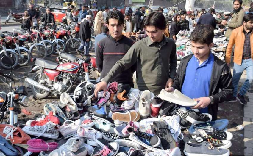 لاہور: لنڈا بازار میں محنت کش پرانے جوتے فروخت کررہے ہیں۔
