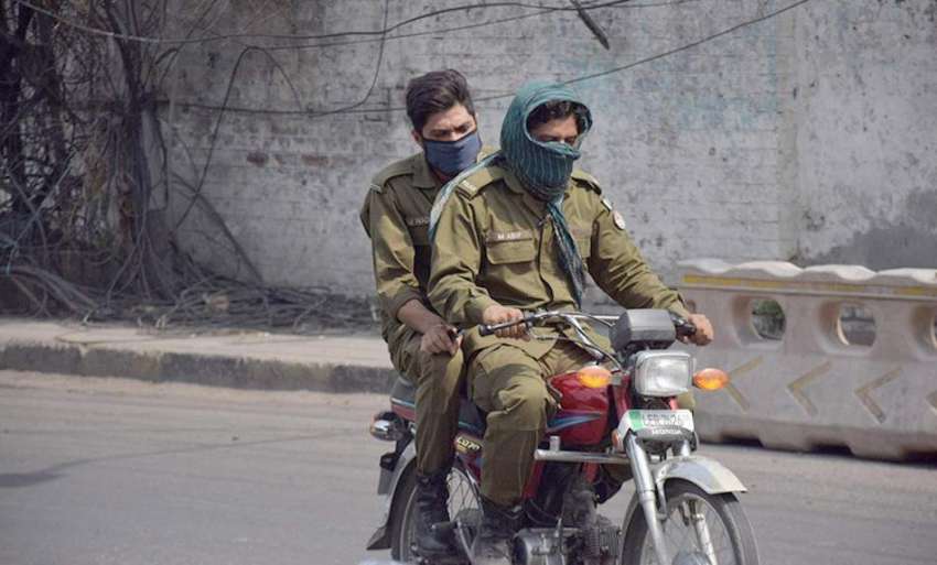 لاہور: ایک موٹر سائیکل سوار پولیس اہلکار گرمی کی شدت سے بچنے ..