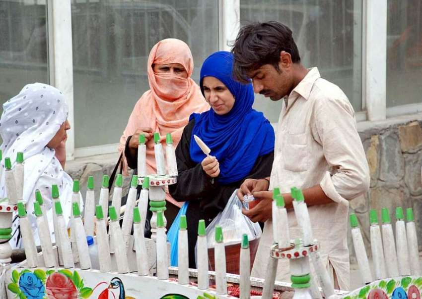 اسلام آباد: خواتین ریڑھی بان سے قلفیاں خرید کر کھا رہی ہیں۔