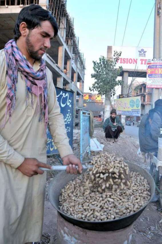 اسلام آباد:ایک دکاندار سڑک کنارے مونگ پھلی بھون رہا ہے۔
