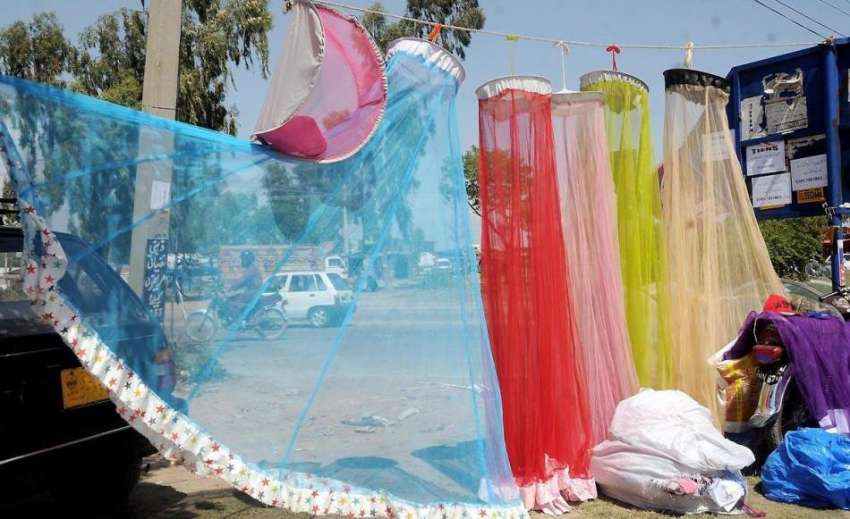 راولپنڈی: سڑک کنارے ایک محنت کش نے مچھردانیاں فروخت کے لیے ..