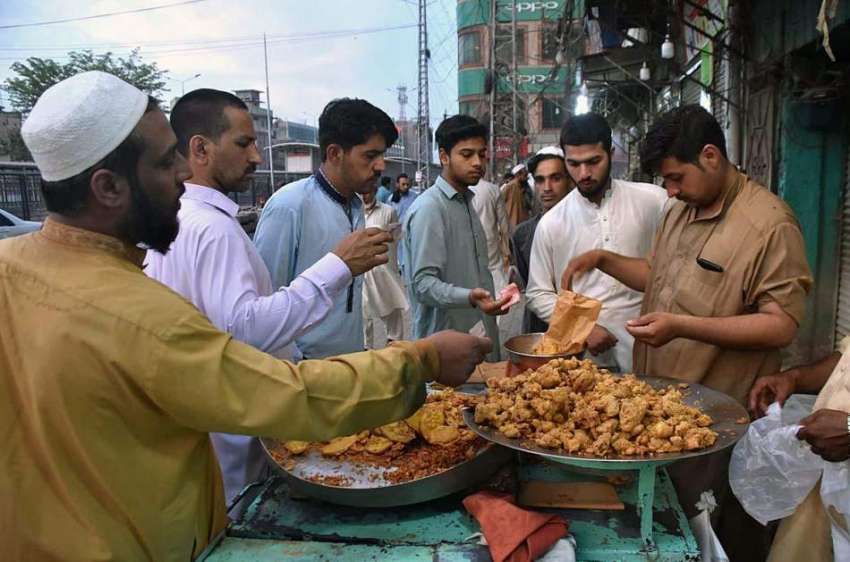 پشاور: شہری افطاری کے لیے ایک دکان سے پکوڑے خرید رہے ہیں۔
