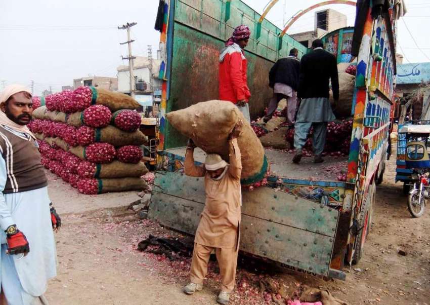 چنیوٹ: مزدور سبزی منڈی میں ٹرک سے پیاز کی بوریاں اتار رہاہے۔