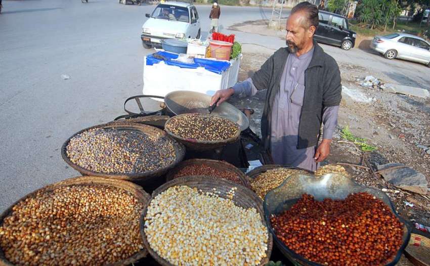 راولپنڈی: ایک دکاندار سڑک کنارے پر صارفین کو راغب کرنے کے ..