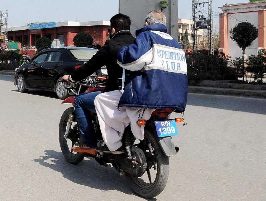 راولپنڈی: ہیلمٹ پہنے بغیر موٹر سائیکل سوار مری روڈ سے گزر ..