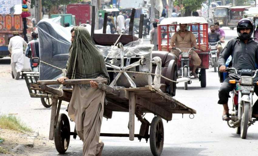 لاہور: ایک محنت کش ہتھ ریڑھی پر سامان رکھے جا رہا ہے۔