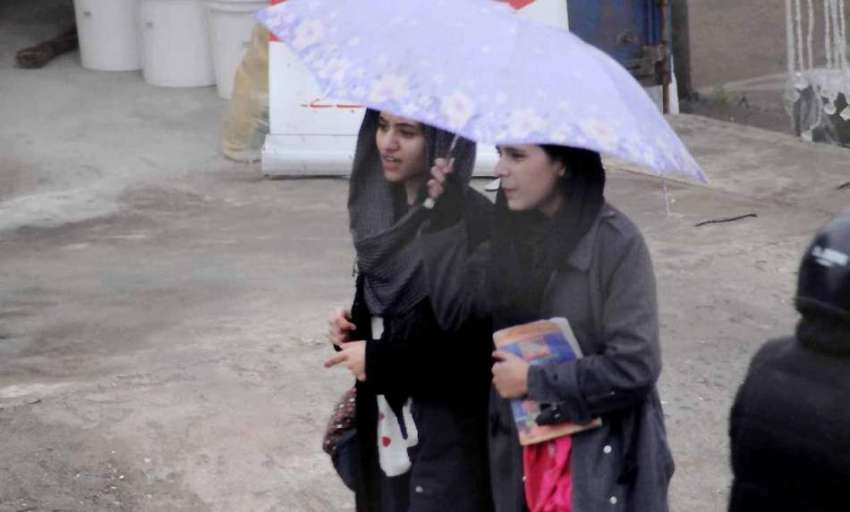 اسلام آباد: طالبات بارش سے بچنے کے لیے چھتری تھامے جارہی ..
