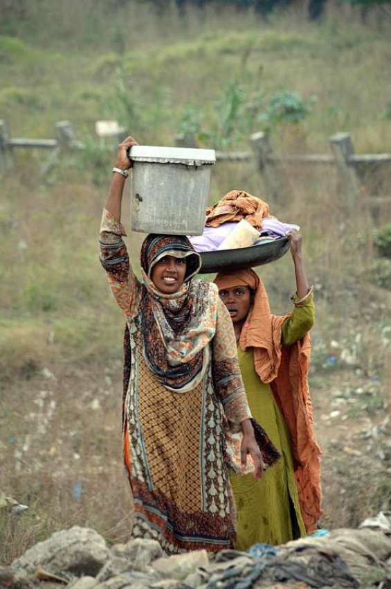 اسلام آباد: خانہ بدوش خواتین کپڑے دھونے کے بعد واپس جارہی ..