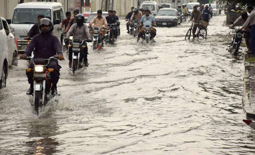لاہور: شہر میں ہونے والی بارش کے بعد ایک شاہراہ پانی میں ..