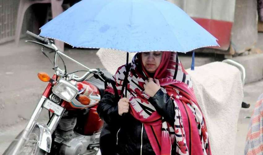 اسلام آباد: بارش سے بچنے کے لیے خاتون نے چھتری تان رکھی ہے۔