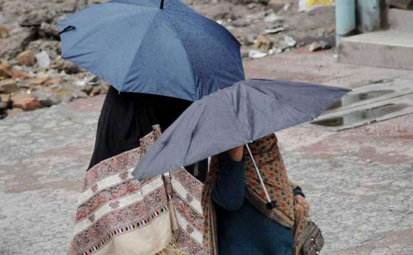 اسلام آباد: خواتین نے بارش سے بچنے کے لیے چھتری تان رکھی ..