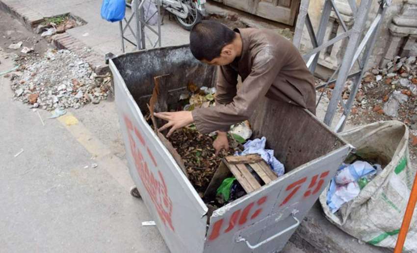 لاہور: ایک محنت کش بچہ کوڑے دان میں کار آمد اشیاء تلاش کررہا ..