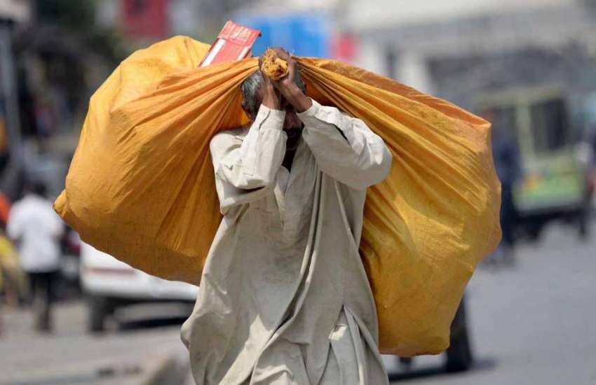 راولپنڈی: مری روڈ پر ایک خانہ بدوش شخص سامان اکھٹا کر کے ..