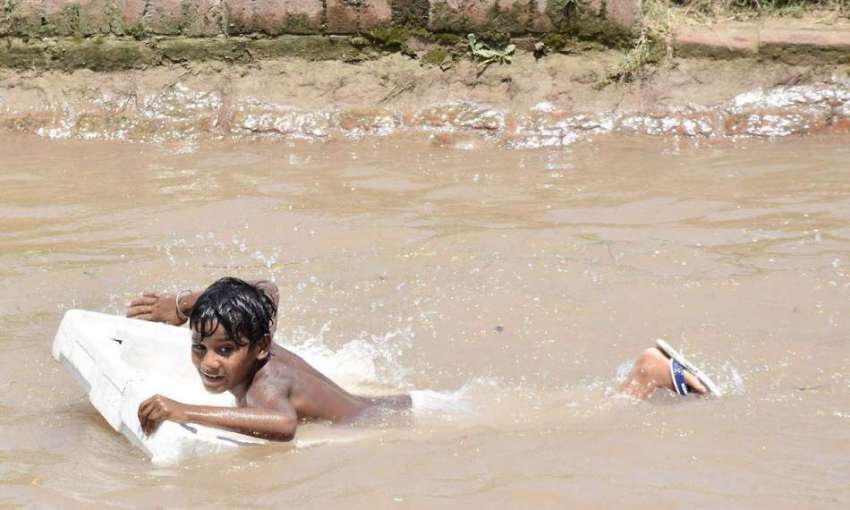 لاہور: ایک بچہ گرمی کی شدت کم کرنے کے لیے نہر میں نہا رہا ..