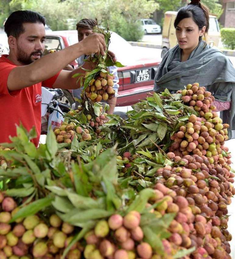 لاہور: خاتون ریڑھی بان سے موسمی پھل (لیچی) خرید رہی ہے۔
