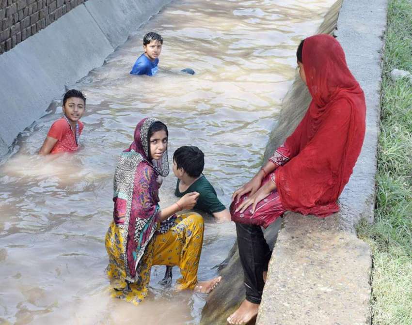 لاہور: بچیاں گرمی کی شدت کم کرنے کے لیے نہر سے ملحقہ کھالے ..