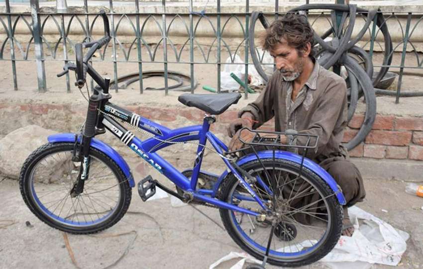 لاہور: نیلا گنبد مارکیٹ میں ای کاریگر سائیکل مرمت کر رہا ..