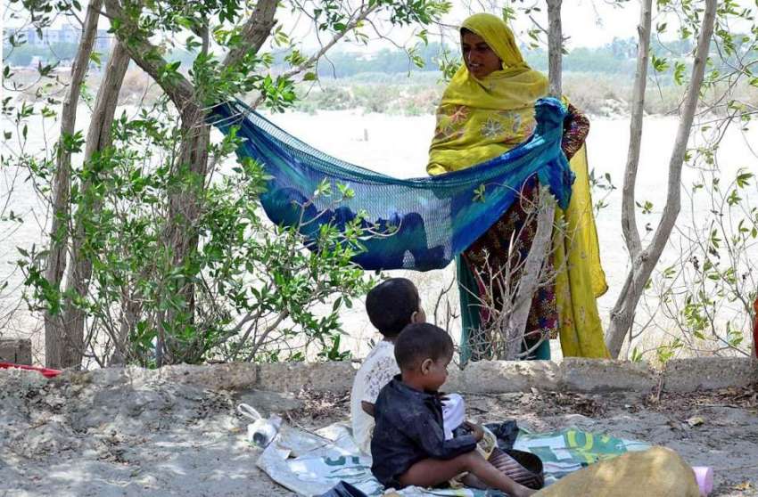 حیدر آباد: خانہ بدوش خاتون اپنے بچوں کو دھوپ کی شدت سے بچانے ..
