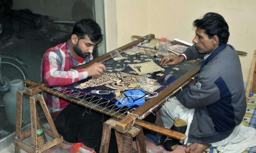 فیصل آباد: محنت کش کپڑے پر ایمبرائیڈری کا کام کر رہا ہے۔