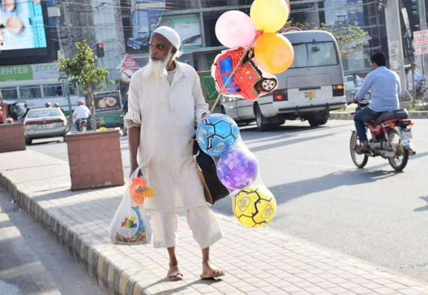 لاہور: ایک محنت کش غبارے اور گیند فروخت کررہا ہے۔