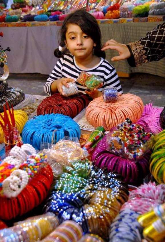 اسلام آباد: عید کی تیاریوں میں مصروف ایک بچی چوڑیاں پسند ..