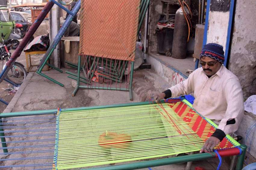 لاہور : ایک کاریگر چار پائی بنا رہا ہے۔
