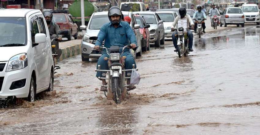 راولپنڈی: موٹر سائیکل سوار بارش کے جمع شدہ پانی سے گزر رہے ..