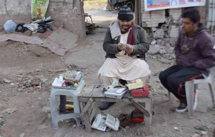 لاہور: کاریگر ٹیلی فون مرمت کررہاہے۔