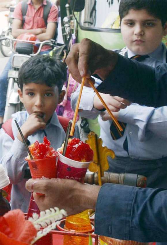 لاہور: سکول سے چھٹی کے بعد بچی برف کے گولے خرید رہے ہیں۔