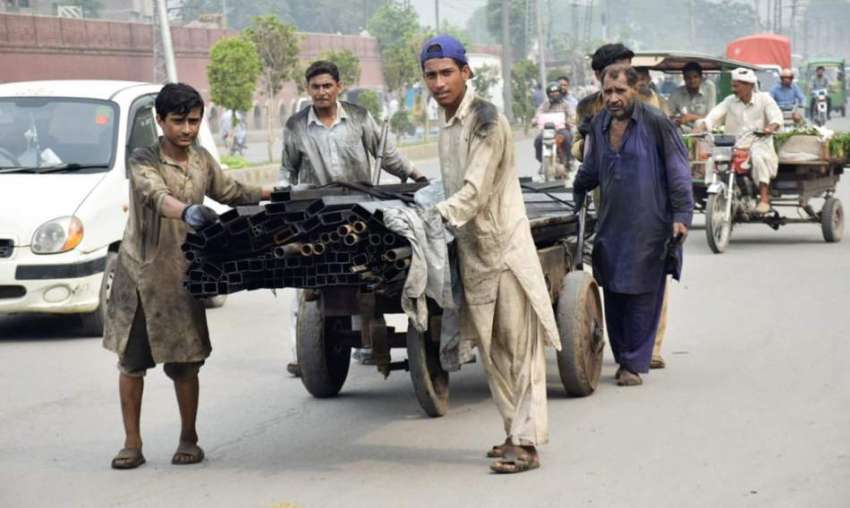 لاہور: مزدور ہتھ ریڑھی پر لوہے کے راڈ رکھے سرکلر روڈ سے گزر ..