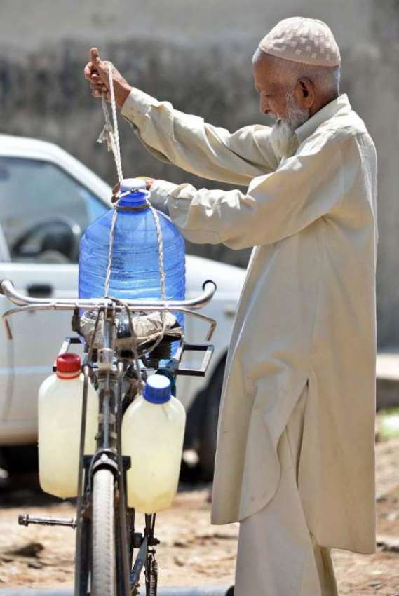 راولپنڈی: ایک معمر شخص پینے کے لیے صاف پانی کے کین سائیکل ..