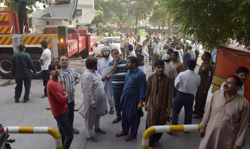 لاہور: مال روڈپر واقع الفلاح بلڈنگ میں آگ لگنے کے بعد لوگ ..