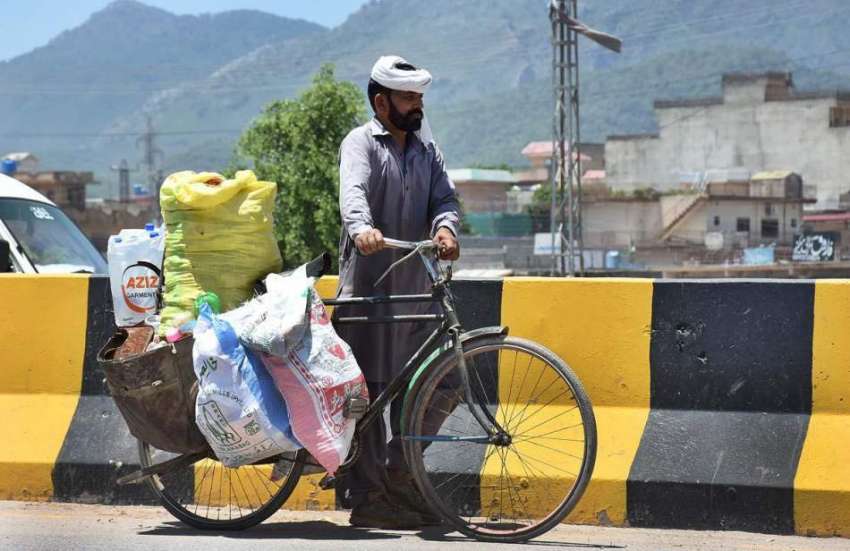 اسلام آباد: محنت کش اپنی سائیکل پر ردی جمع کرنے کے بعد واپس ..