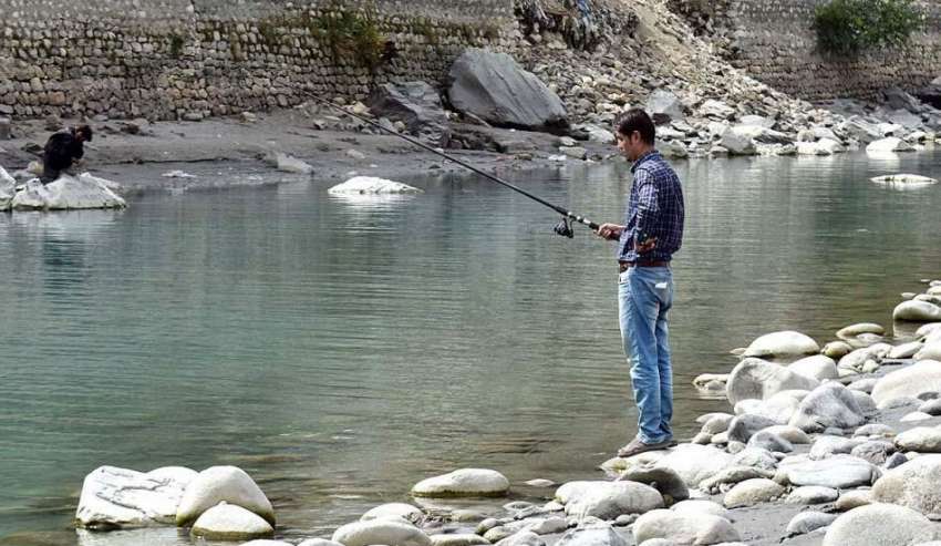 گلگت: ایک نوجوان مچھلی کا شکار کر رہا ہے۔