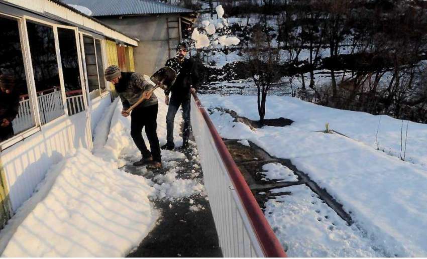 مری: برفباری کے بعد مکین گھر کے آگے سے برف ہٹا رہے ہیں۔