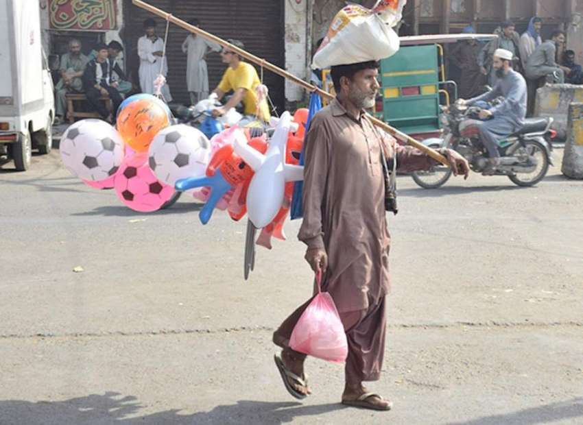 لاہور: ایک محنت کش بچوں کے کھلونے فروحت کر رہاہے۔