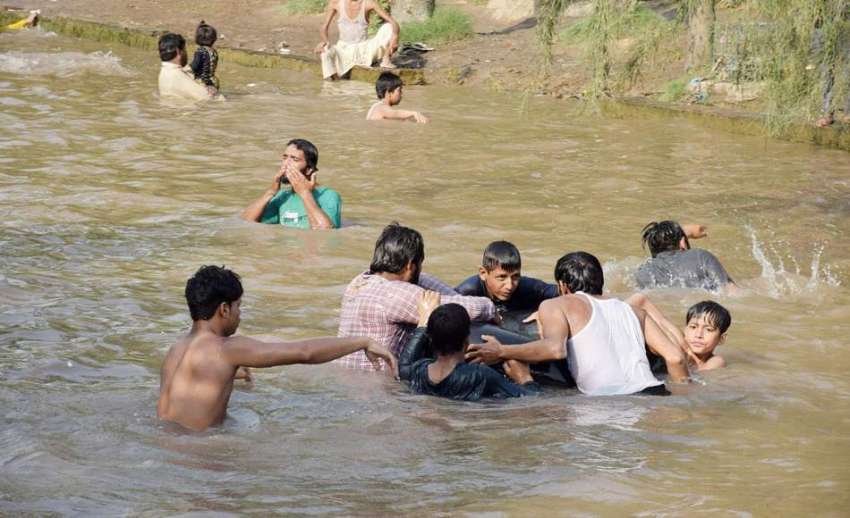 لاہور: لڑکے گرمی کی شدت کم کرنے کے لیے نہر میں نہا رہے ہیں۔