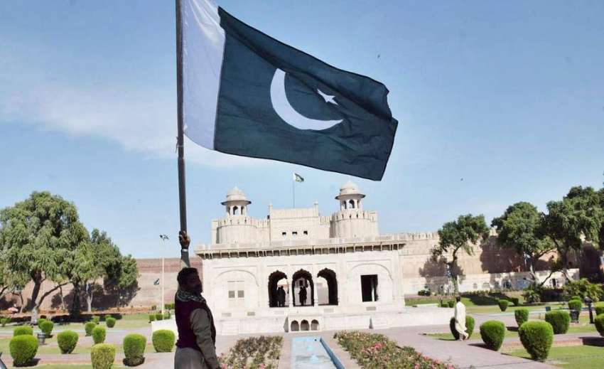 لاہور: حضوری باغ میں ایک شخص قومی پرچم لہرا رہا ہے۔